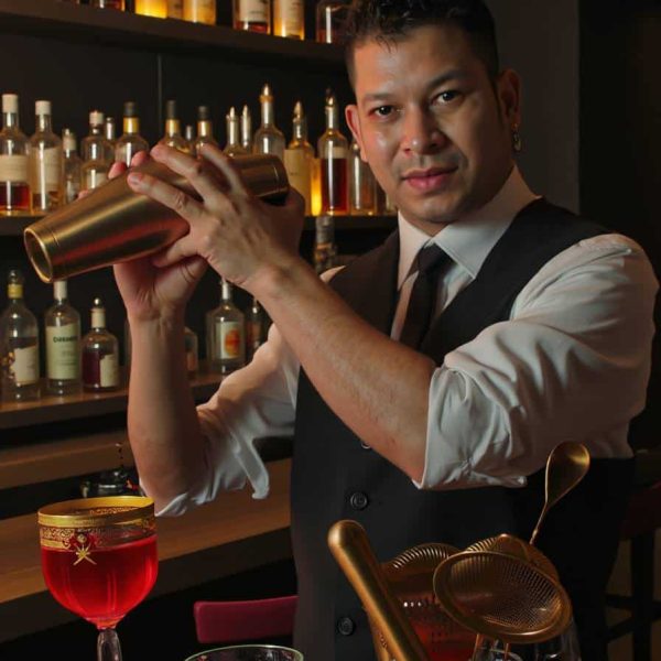Bartender mixing cocktails at elegant bar counter
