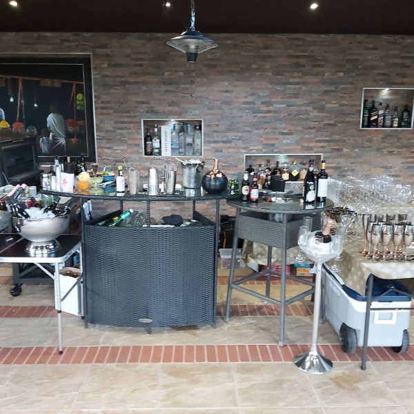 Outdoor cocktail bar setup with assorted drinks.