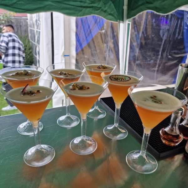 Seven passion fruit cocktails on outdoor table